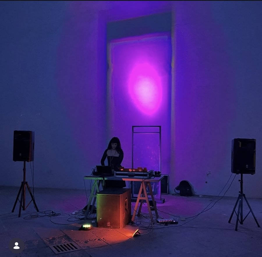 Lindred performing in installation space with purple and pink lighting