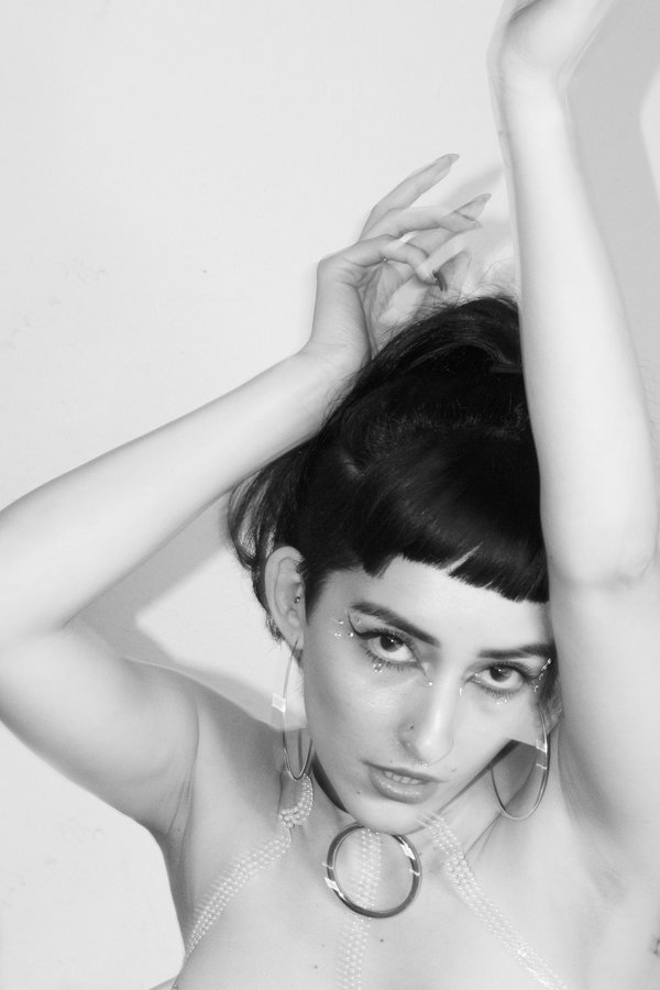 Lindred black and white portrait with hoop earrings and crystal makeup